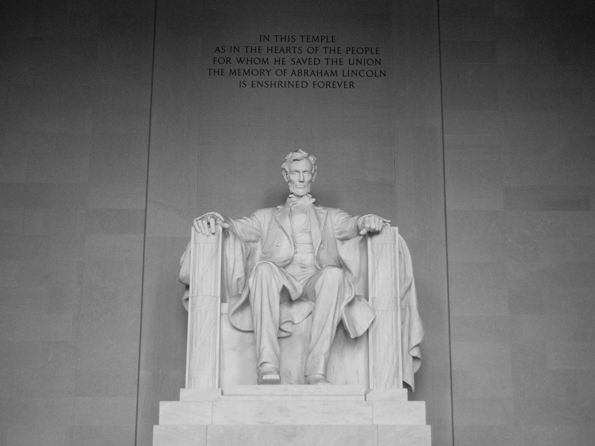 Grey and white photo of the Lincoln Museum statue of Lincoln sitting on chair in DC