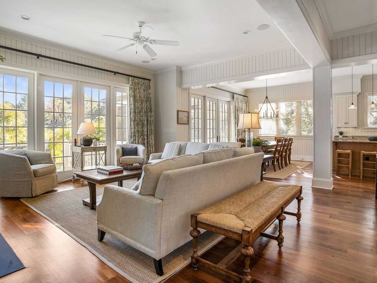 Inside this bright and open living area, tall windows let in tons of light while the comfy furniture and warm wood floors make it easy to feel at home.