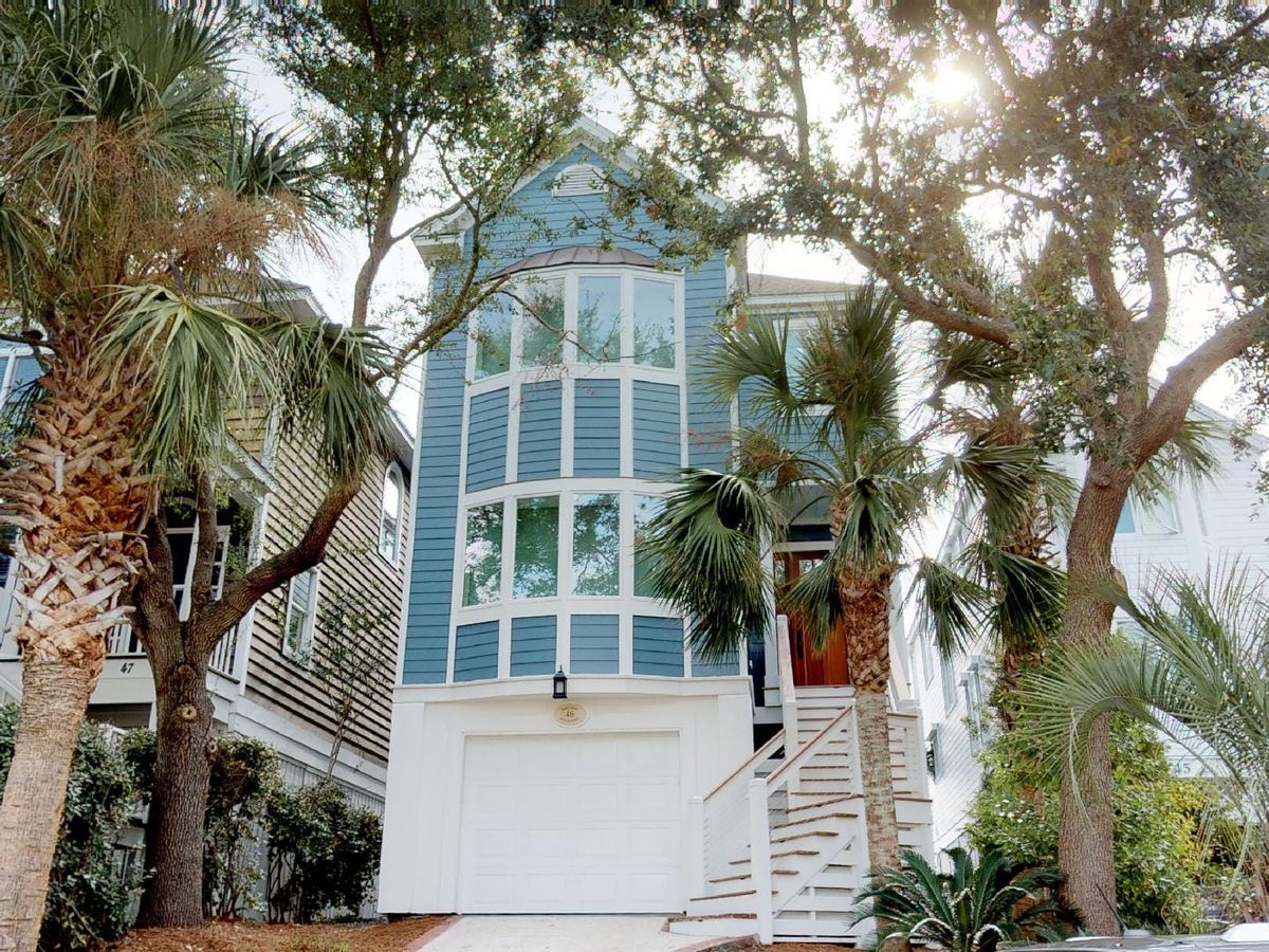 A bright and stylish beach house with a huge navy sectional, light wood floors, and tropical touches. Perfect for big family movie nights or just relaxing after a day in the sun.