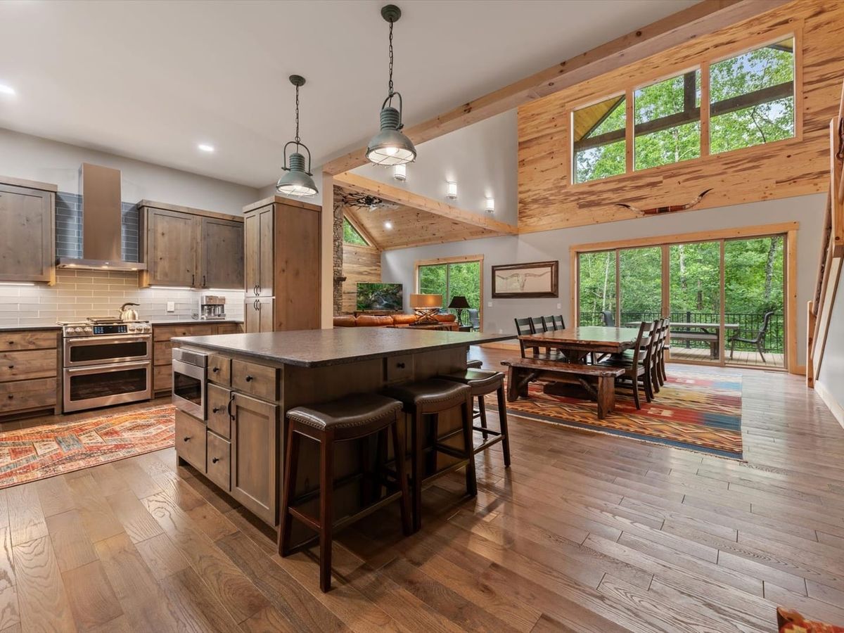 This open kitchen and dining space blends rustic wood charm with modern finishes. It’s made for gathering, cooking, and enjoying the forest views just outside.
