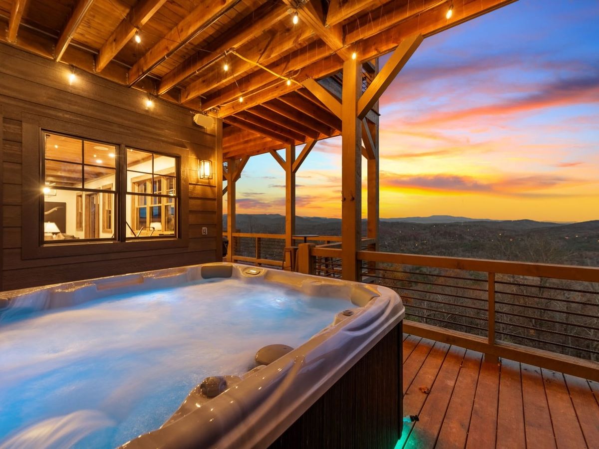 Bubbling hot tub on cabin balcony overlooking sunset views