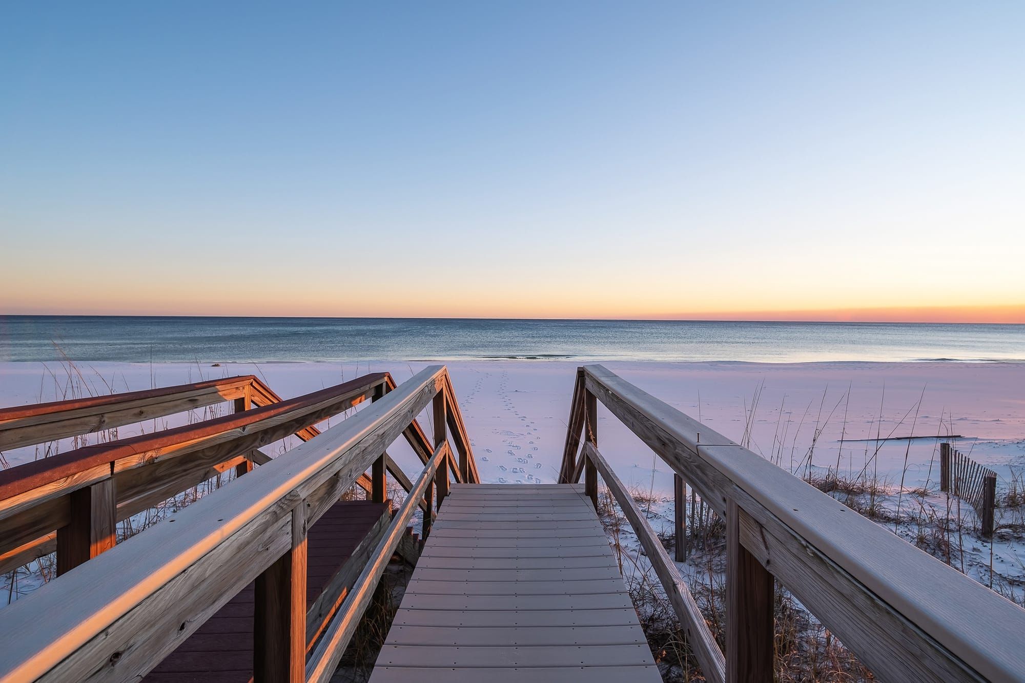 Stunning beachfront row of luxury homes with pristine white sand and clear blue water along Florida’s Gulf Coast.