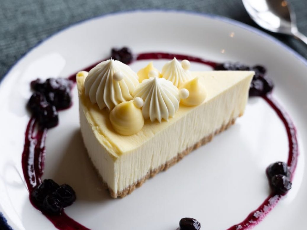 Delicious cheesecake surrounded by blueberry drizzle and blueberries