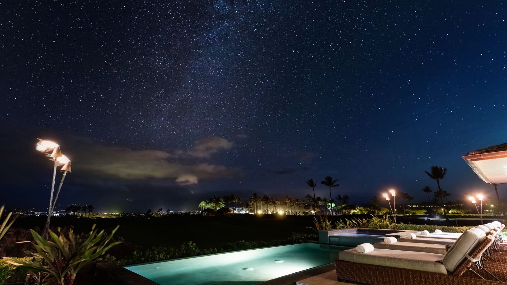 Elegant Escape features a glowing private pool and lounge chairs beneath a clear, star-filled Hawaiian sky. The peaceful outdoor setting gives guests a beautiful place to unwind and enjoy Hawaii after dark.