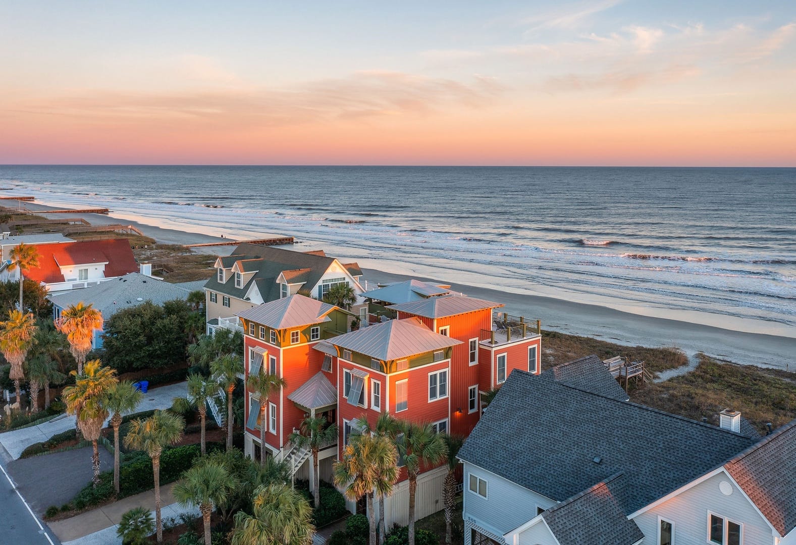 Colorful homes on the beach with ocean crashing into the shore
