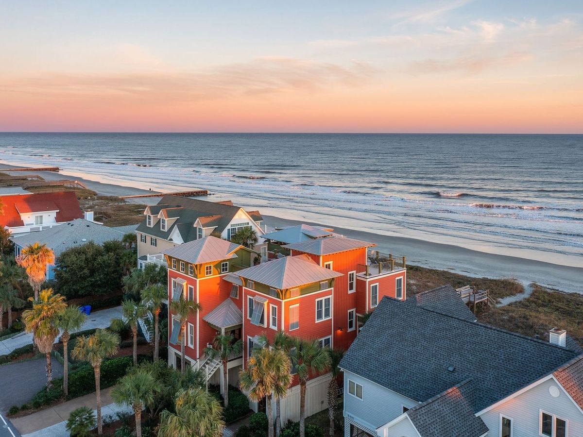 Colorful homes on the beach with ocean crashing into the shore