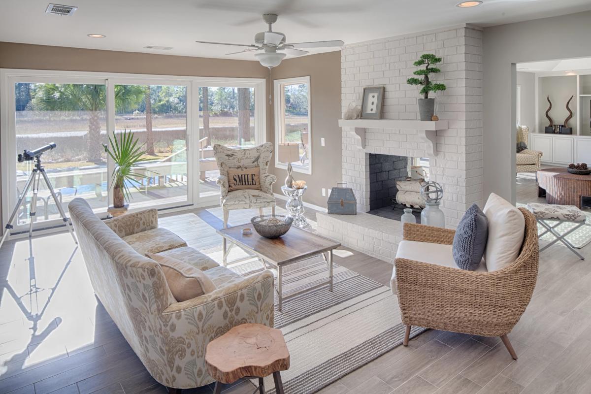 Living room with a fireplace overlooking a private pool.