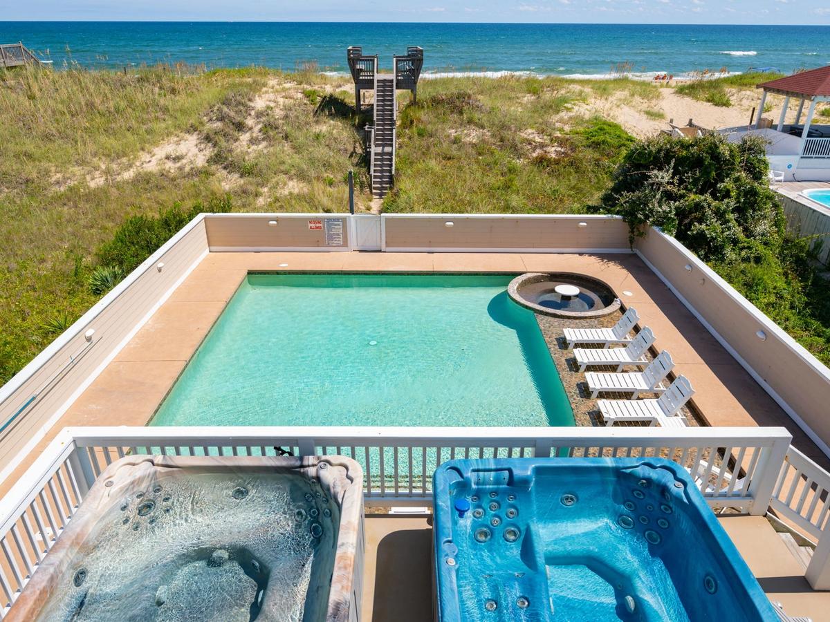 Two private hot tubs side by side overlooking private pool and wooden steps leading to beach access