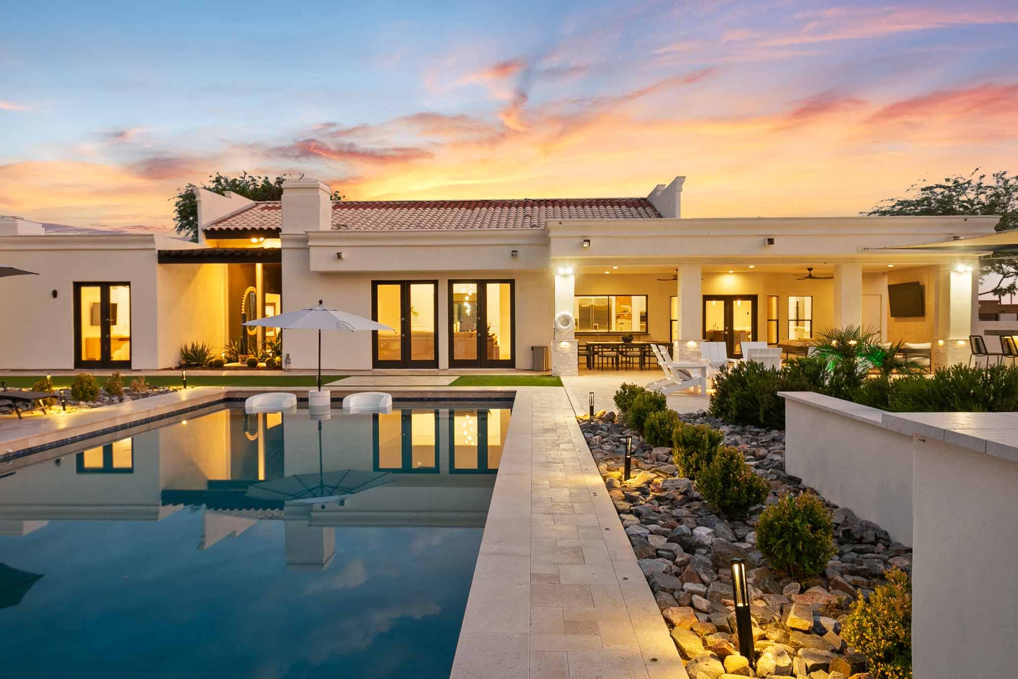 Grey and black house in arizona with moose statue in the front and sunset going down in the background