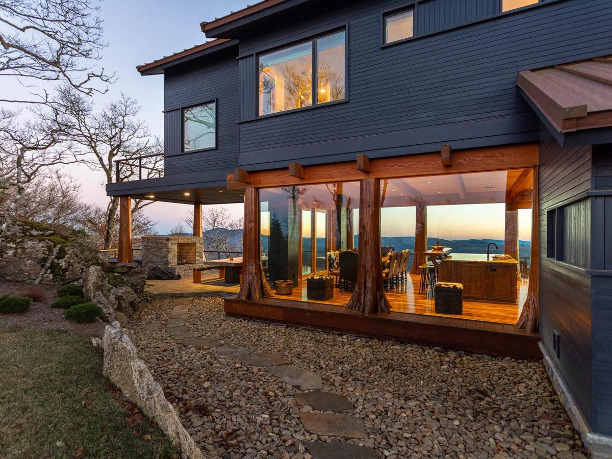 Exterior of cabin rental with open windows and mountain views