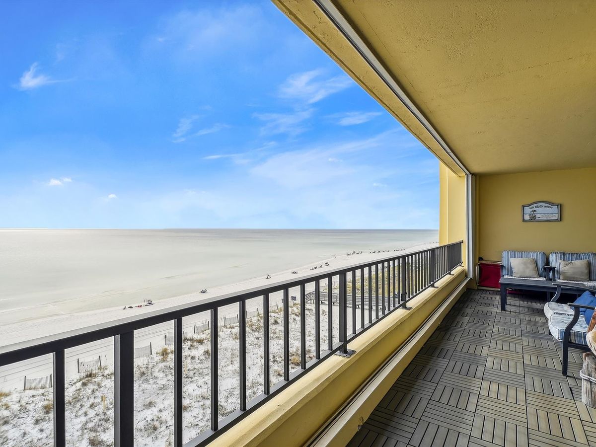 A beachfront condo with panoramic views of white sand and turquoise water. The cozy balcony seating invites guests to unwind and enjoy the gentle sound of the waves in Destin.
