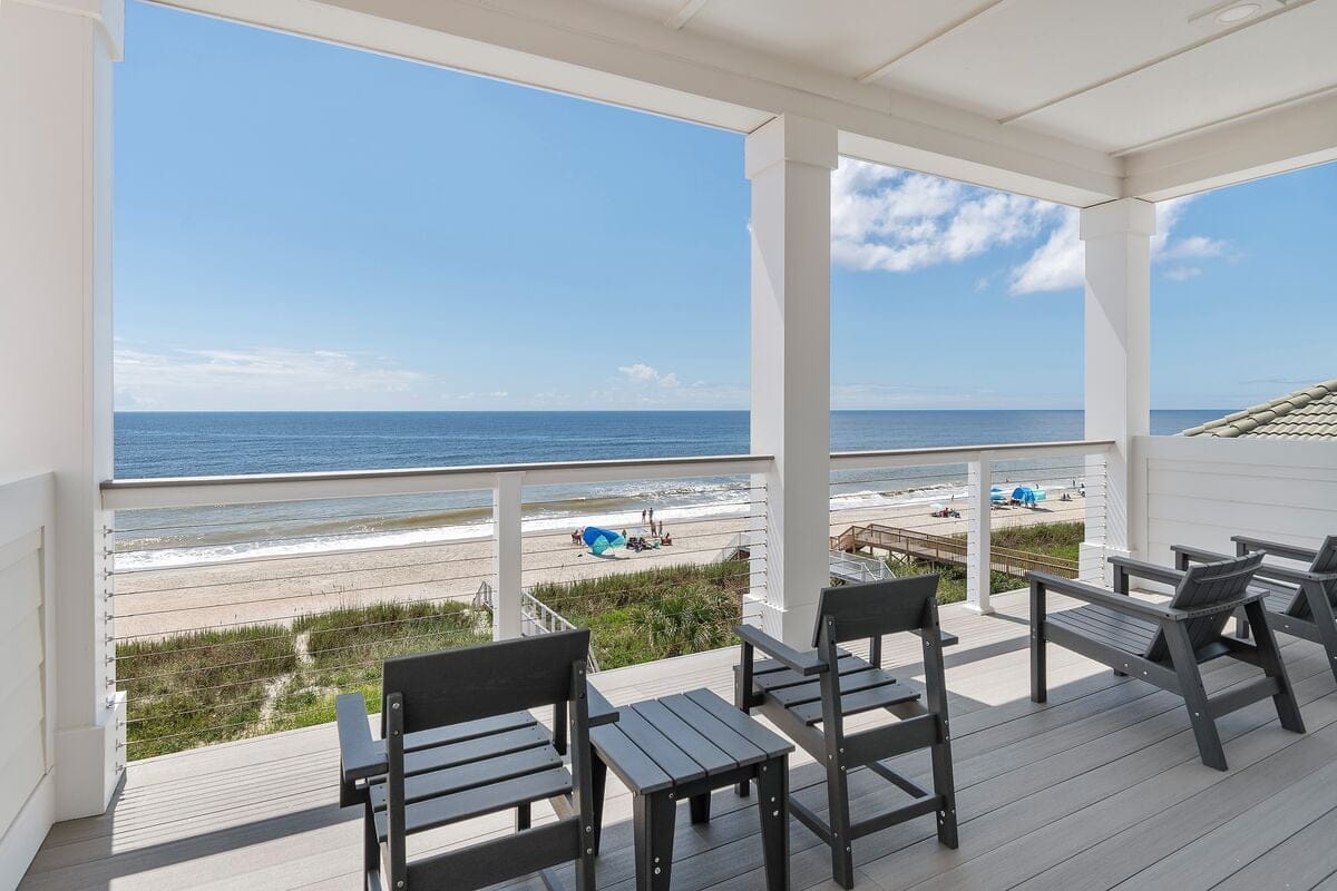 Spacious beachfront vacation home with a large deck overlooking the ocean and plenty of lounge chairs for groups. Perfect for big family reunions or retreats, this coastal getaway blends comfort and beach views for up to 39 guests.
