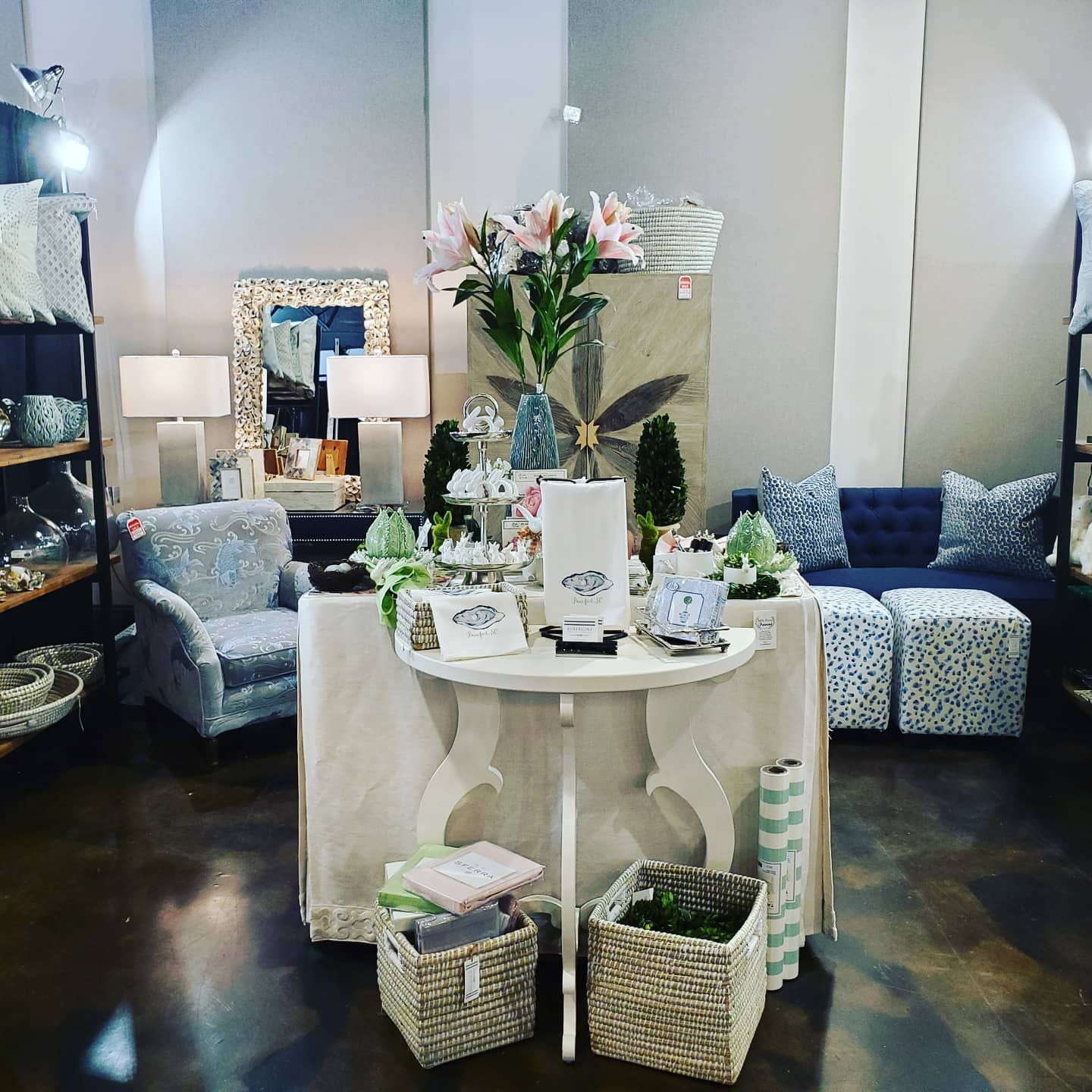A stylish interior display inside Aubergine Home Collection featuring coastal décor, furniture, and home accents. The shop offers curated pieces perfect for beach-inspired homes and gifts.