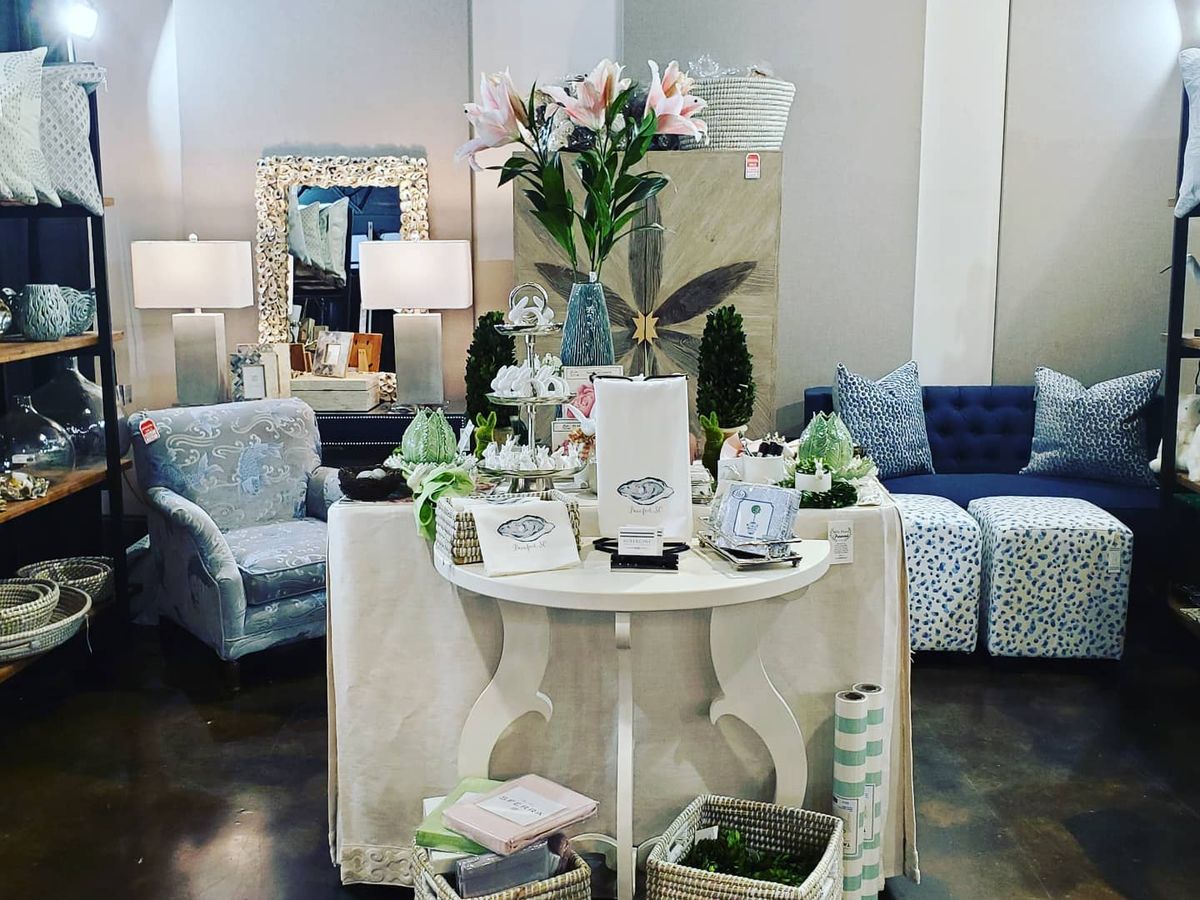 A stylish interior display inside Aubergine Home Collection featuring coastal décor, furniture, and home accents. The shop offers curated pieces perfect for beach-inspired homes and gifts.