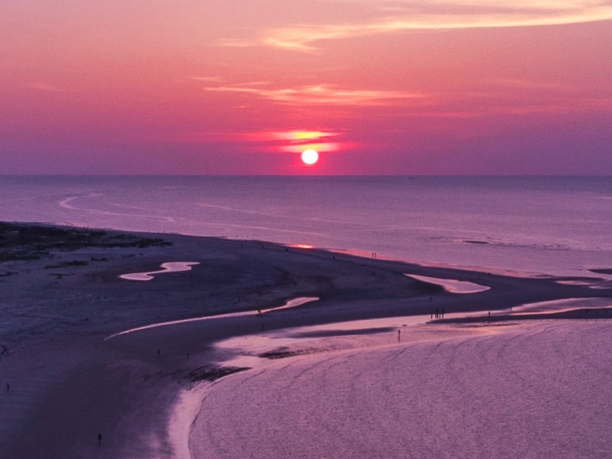Pink and purple sunset with colors on serene beach