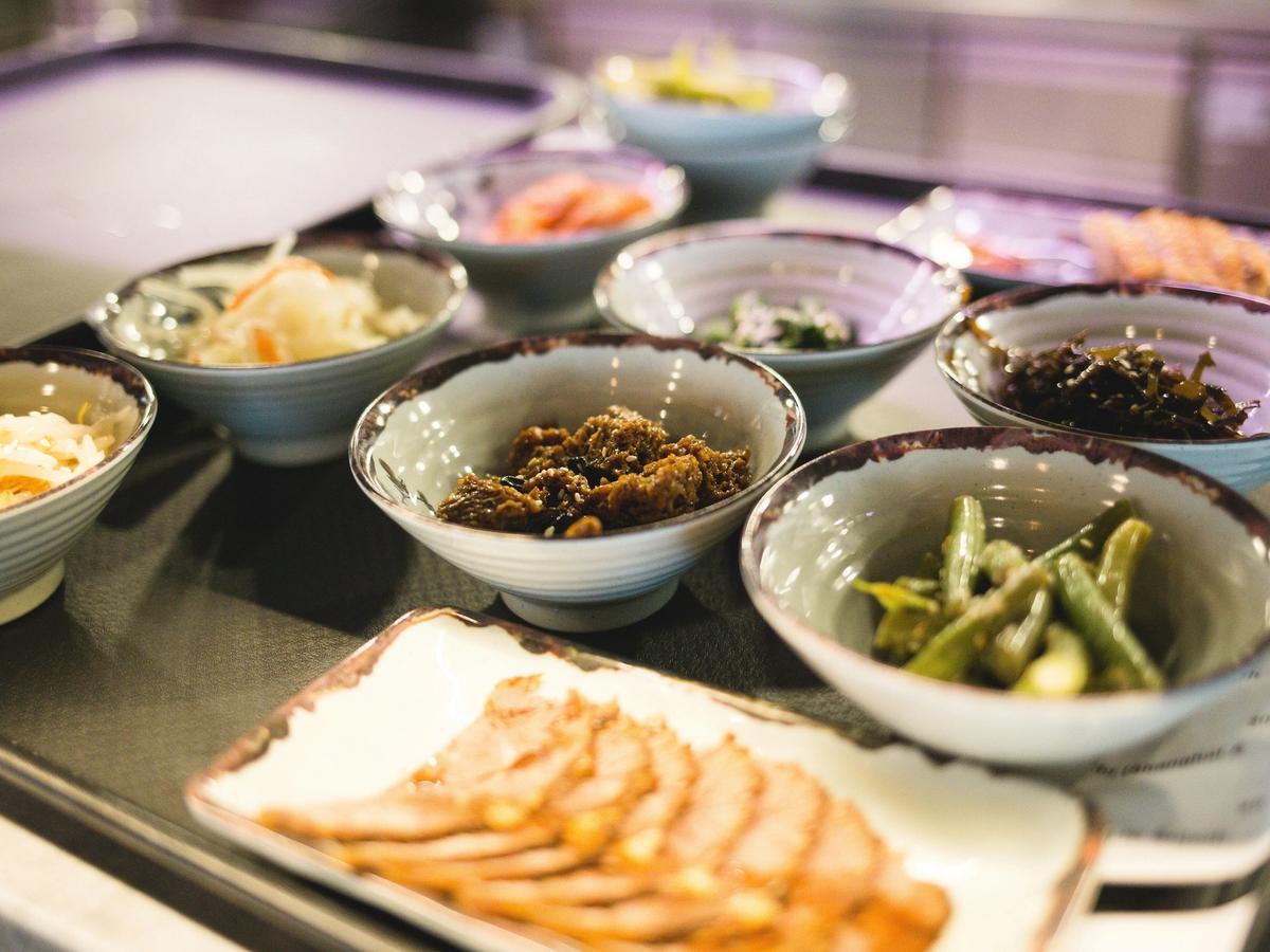 Array of global cuisine in different ceramic bowls on tray