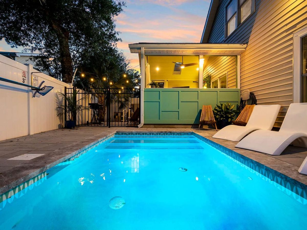 Bright and inviting, this modern home features a sleek blue pool surrounded by lounge chairs and cozy seating. Perfect for families, it’s designed for lazy afternoons in the sun and relaxed nights under string lights.