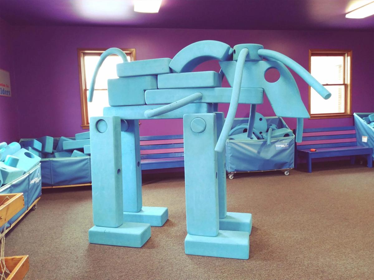 Bright blue foam blocks fill a colorful playroom where children can build creative structures and let their imaginations run wild. The playful setup makes learning fun in this interactive family museum.