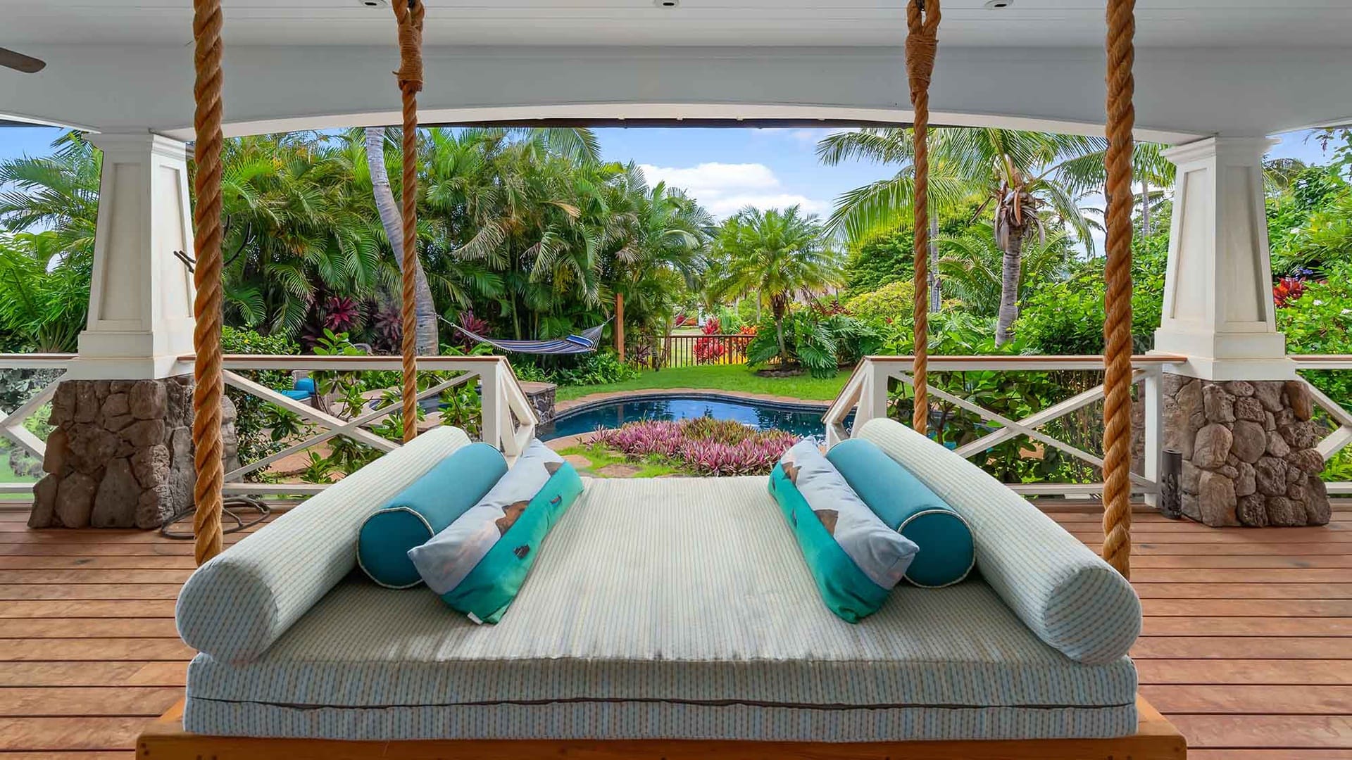 Swinging day bed overlooking private pool, hammock, and garden in backyard of Kauai cottage