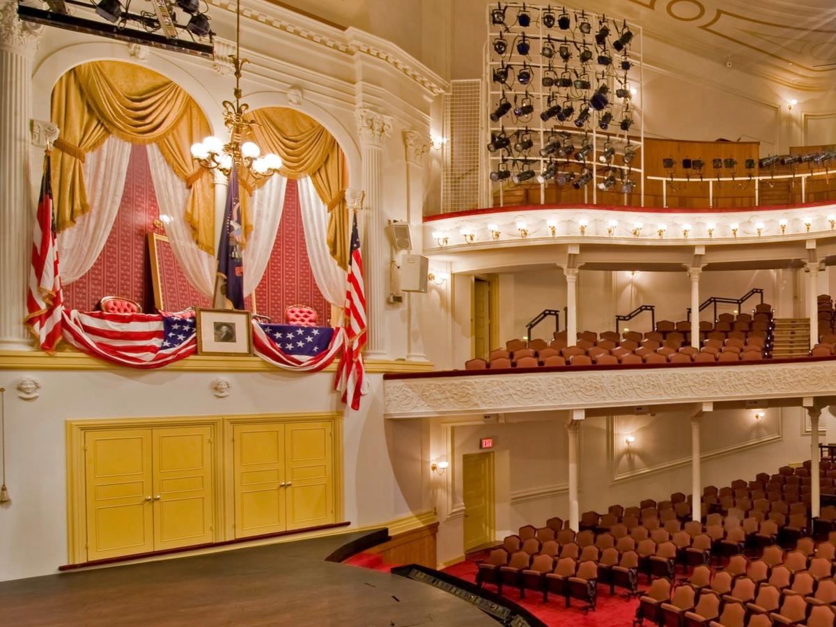 Velvet red curtain at theatre with lights shining on it