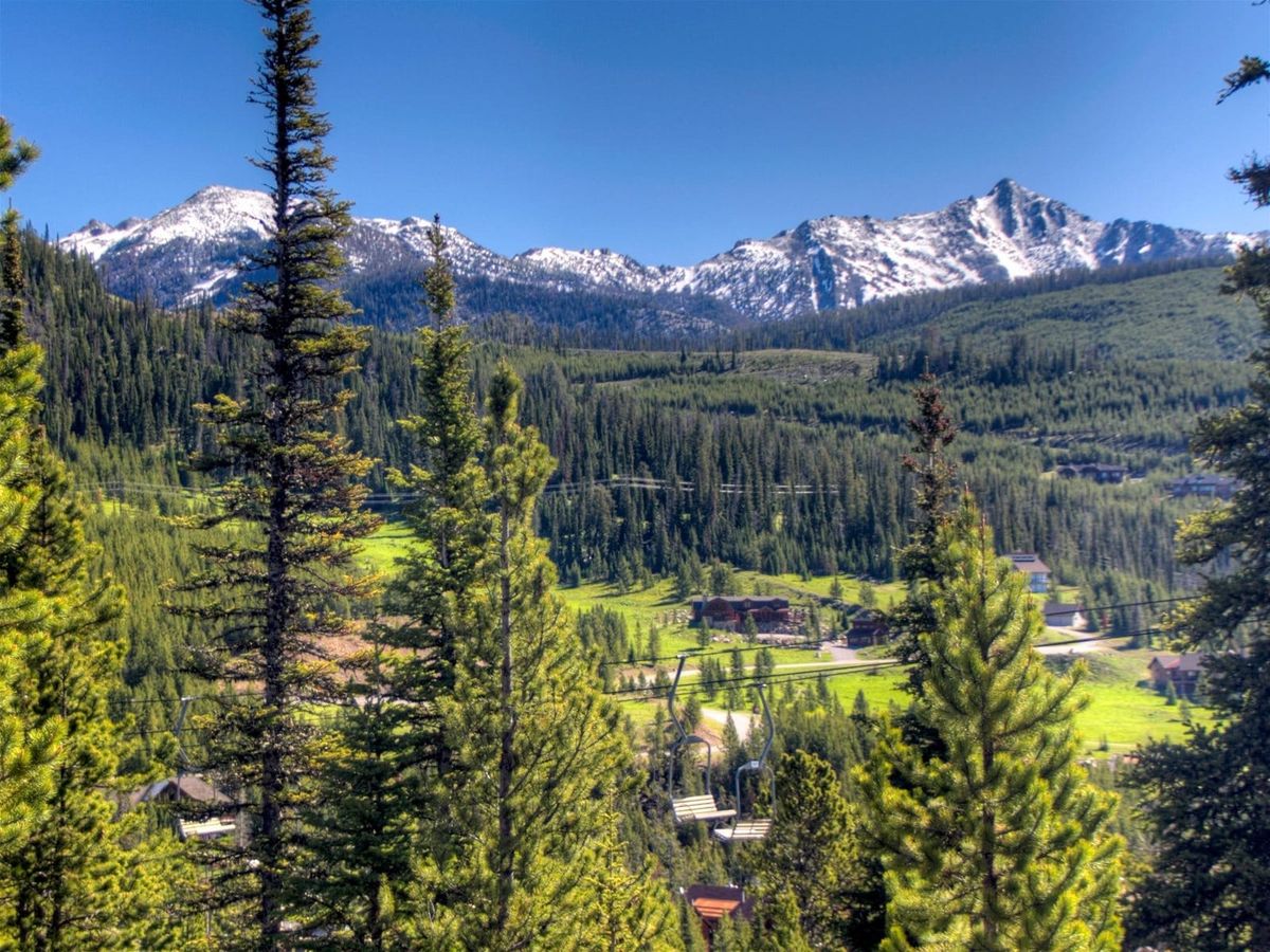 Beehive Basin trail in Big Sky features a quiet alpine pond reflecting rugged peaks and wildflowers in bloom. One of the most iconic hikes in Montana for nature lovers.