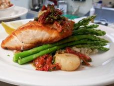 Juicy fillet rest on a plate with roasted veggies and a drizzle of sauce at The Colington Café. The dish is elegant yet hearty, showing why this spot is a go-to for special nights out.