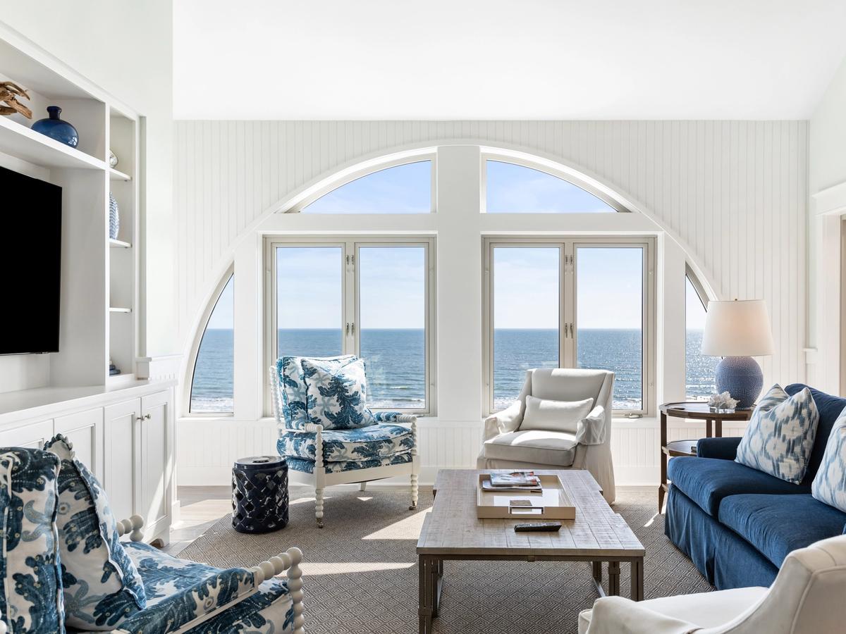 Large windows overlooking the ocean with white archway