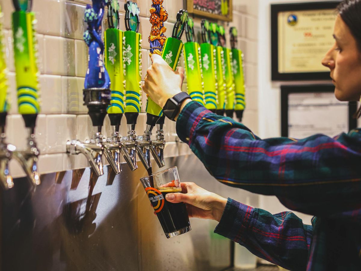 A colorful row of mixed craft cocktails sits on the counter at Wicked Weed's Funkatorium in Asheville. Known for its sour beer lineup and bold flavors, this brewery is a must-visit for anyone exploring Asheville’s unique beer scene.