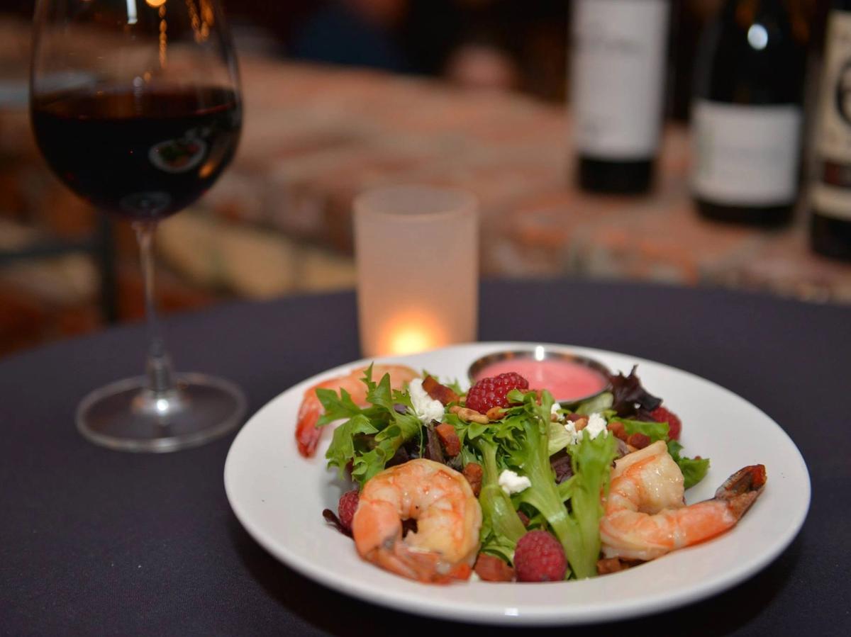 A fresh shrimp and raspberry salad with a glass of red wine sits on a table, creating the perfect dining experience. Sunriver offers excellent restaurants like Marcello’s Cucina Italiana where you can enjoy local flavors in a warm atmosphere.
