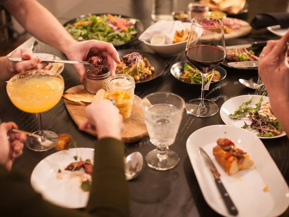 A lively table set with colorful plates, craft cocktails, and farm-fresh dishes. Prerogative Kitchen serves up creative bites in a cozy atmosphere.