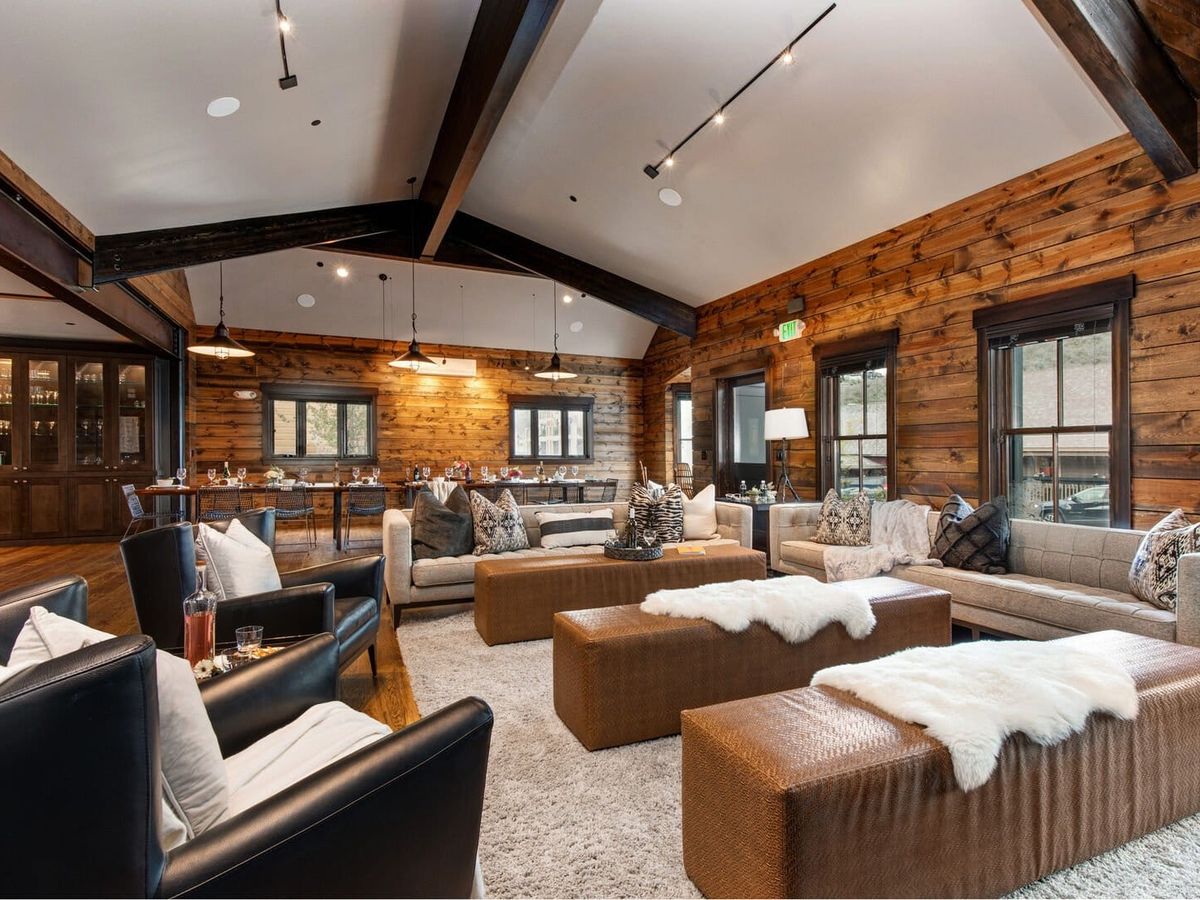 Interior of living room with brown leather benches and white, fur throws