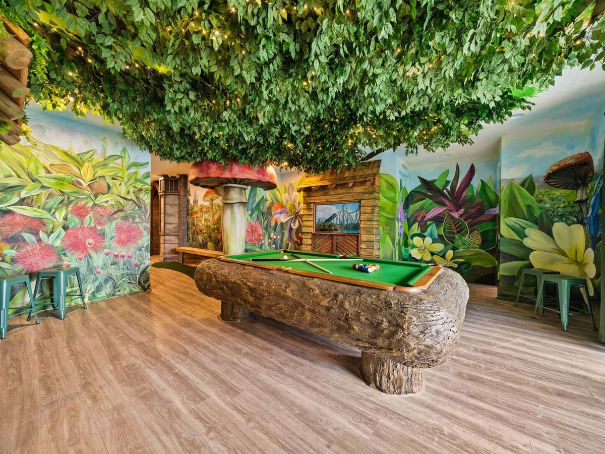 Fairy-field and outdoor themed game room with pool table and flowers on the wall