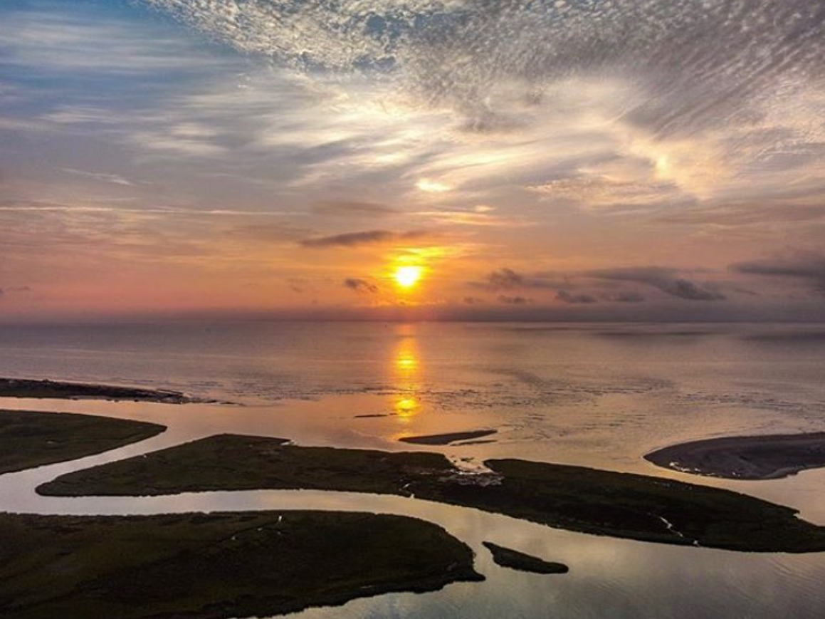 Sunset shining over beach and water at goulds inlet