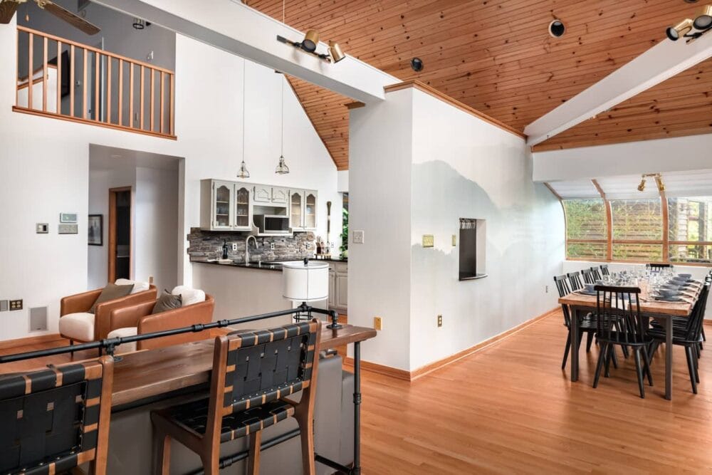 A bright, open-concept living and dining area with wood ceilings and modern decor. The space feels warm and inviting, offering a luxurious yet homely atmosphere perfect for gatherings and special occasions.