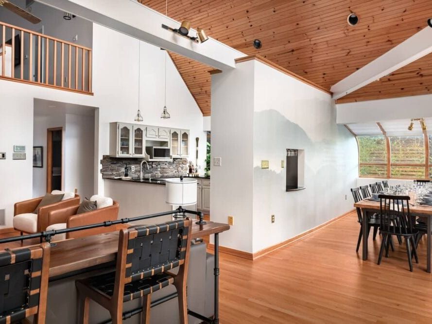 A bright, open-concept living and dining area with wood ceilings and modern decor. The space feels warm and inviting, offering a luxurious yet homely atmosphere perfect for gatherings and special occasions.