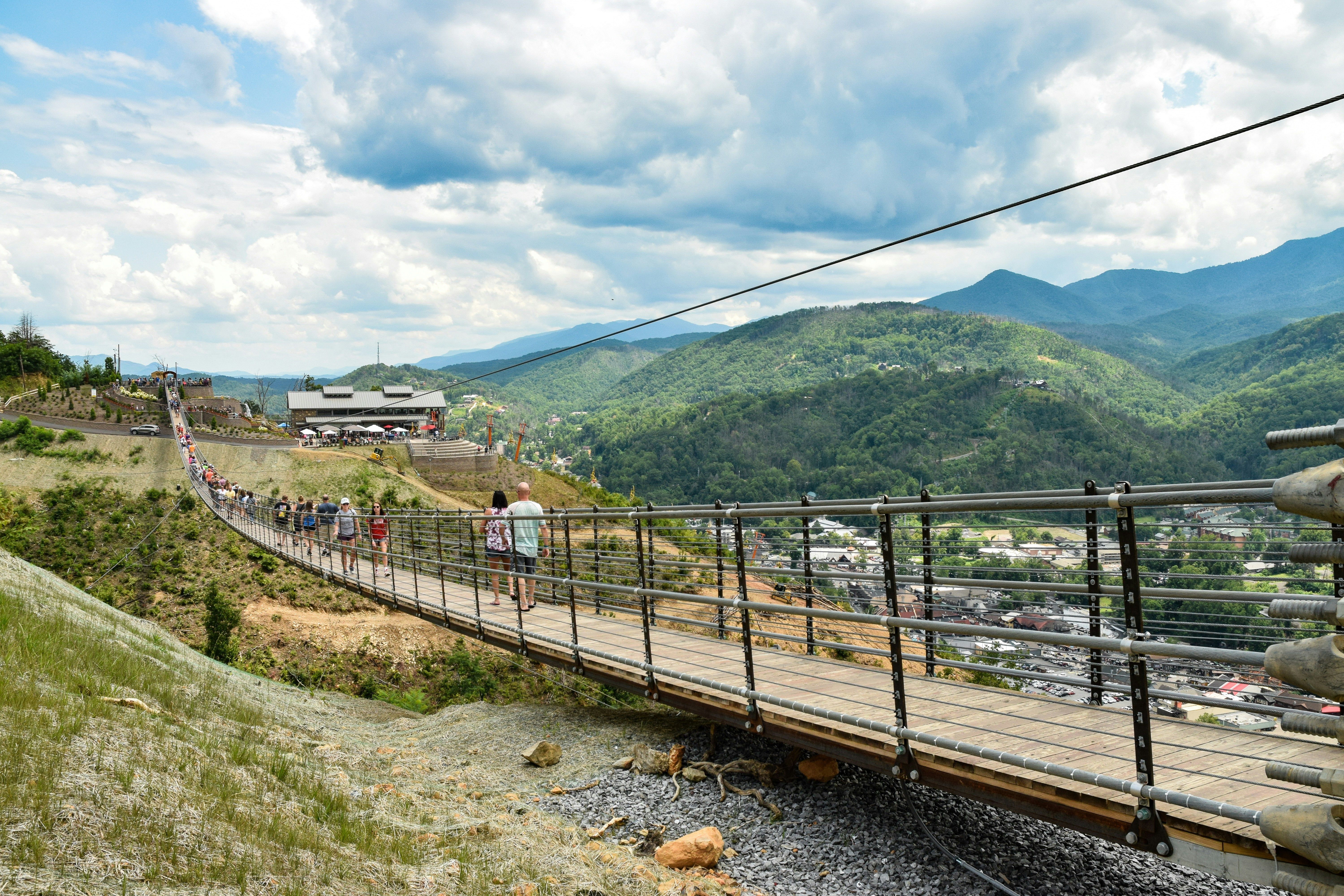 Visitors walk across the Gatlinburg SkyBridge, the longest pedestrian suspension bridge in North America, with panoramic views of the Great Smoky Mountains.