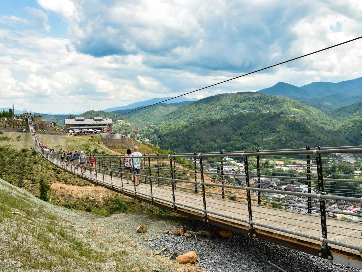 Visitors walk across the Gatlinburg SkyBridge, the longest pedestrian suspension bridge in North America, with panoramic views of the Great Smoky Mountains.