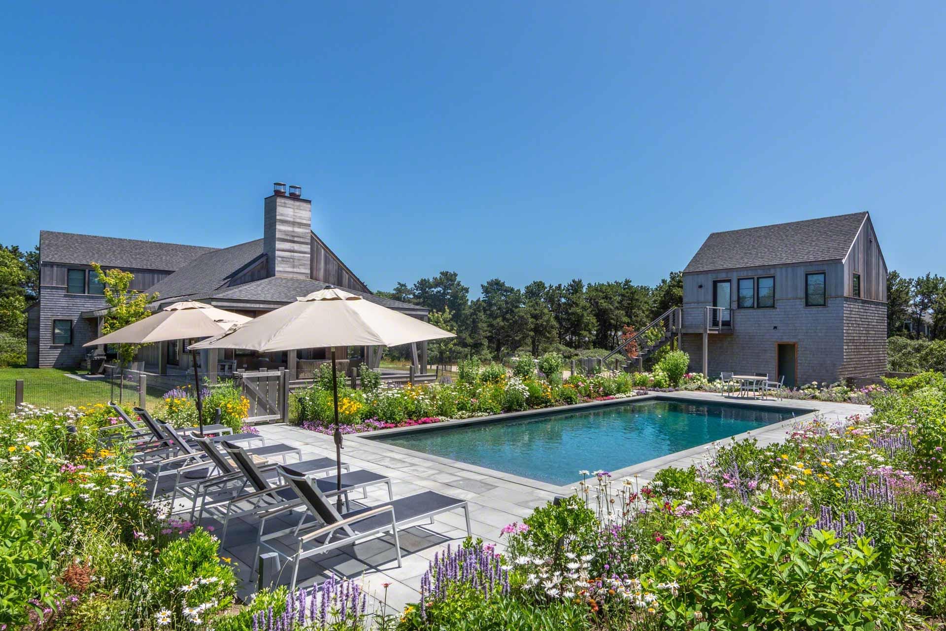 Kat Mali 05 is a stunning Martha’s Vineyard escape with a private pool surrounded by colorful summer blooms. Its modern design and peaceful garden make it ideal for sunny afternoons and family gatherings by the water.