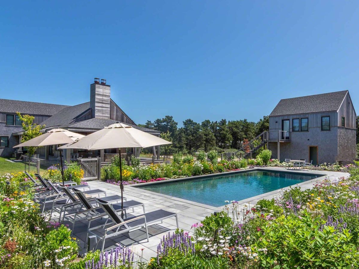Kat Mali 05 is a stunning Martha’s Vineyard escape with a private pool surrounded by colorful summer blooms. Its modern design and peaceful garden make it ideal for sunny afternoons and family gatherings by the water.