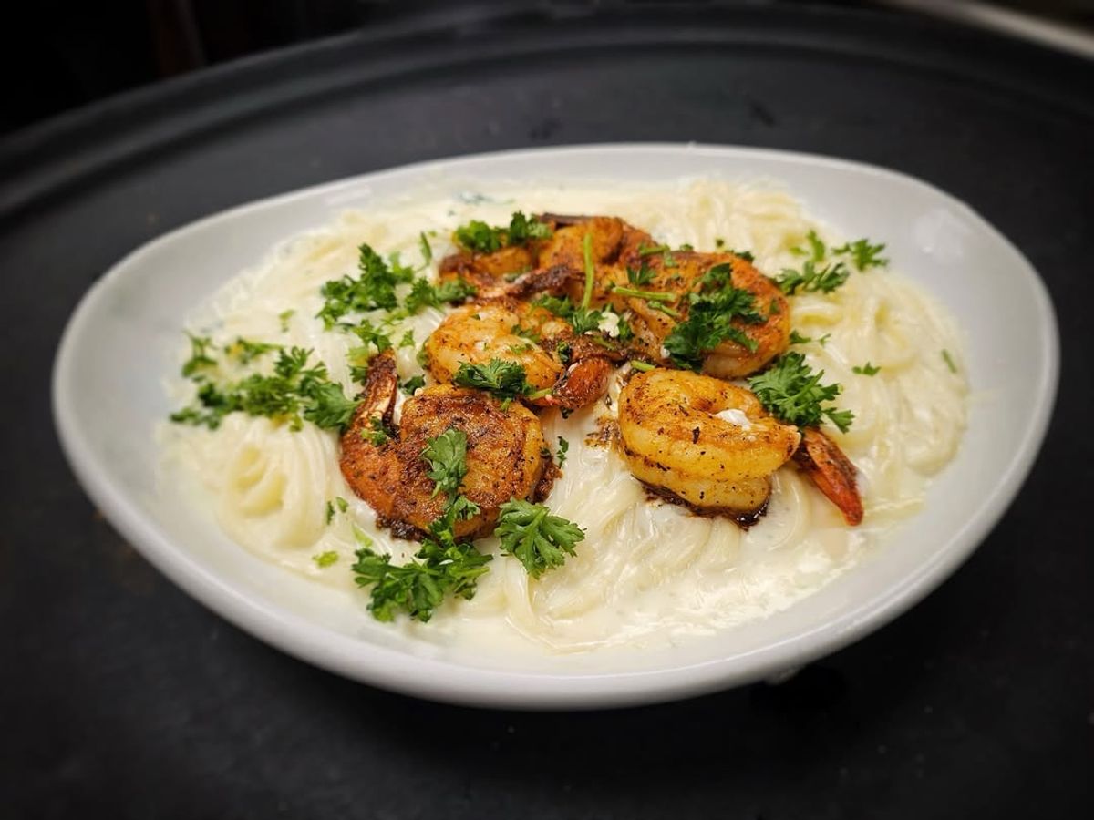 Creamy shrimp Alfredo pasta topped with blackened shrimp and fresh parsley. A rich, comforting meal that brings together seafood and cheesy goodness on one plate.