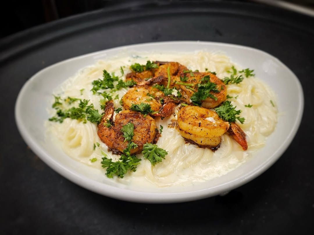 Creamy shrimp Alfredo pasta topped with blackened shrimp and fresh parsley. A rich, comforting meal that brings together seafood and cheesy goodness on one plate.