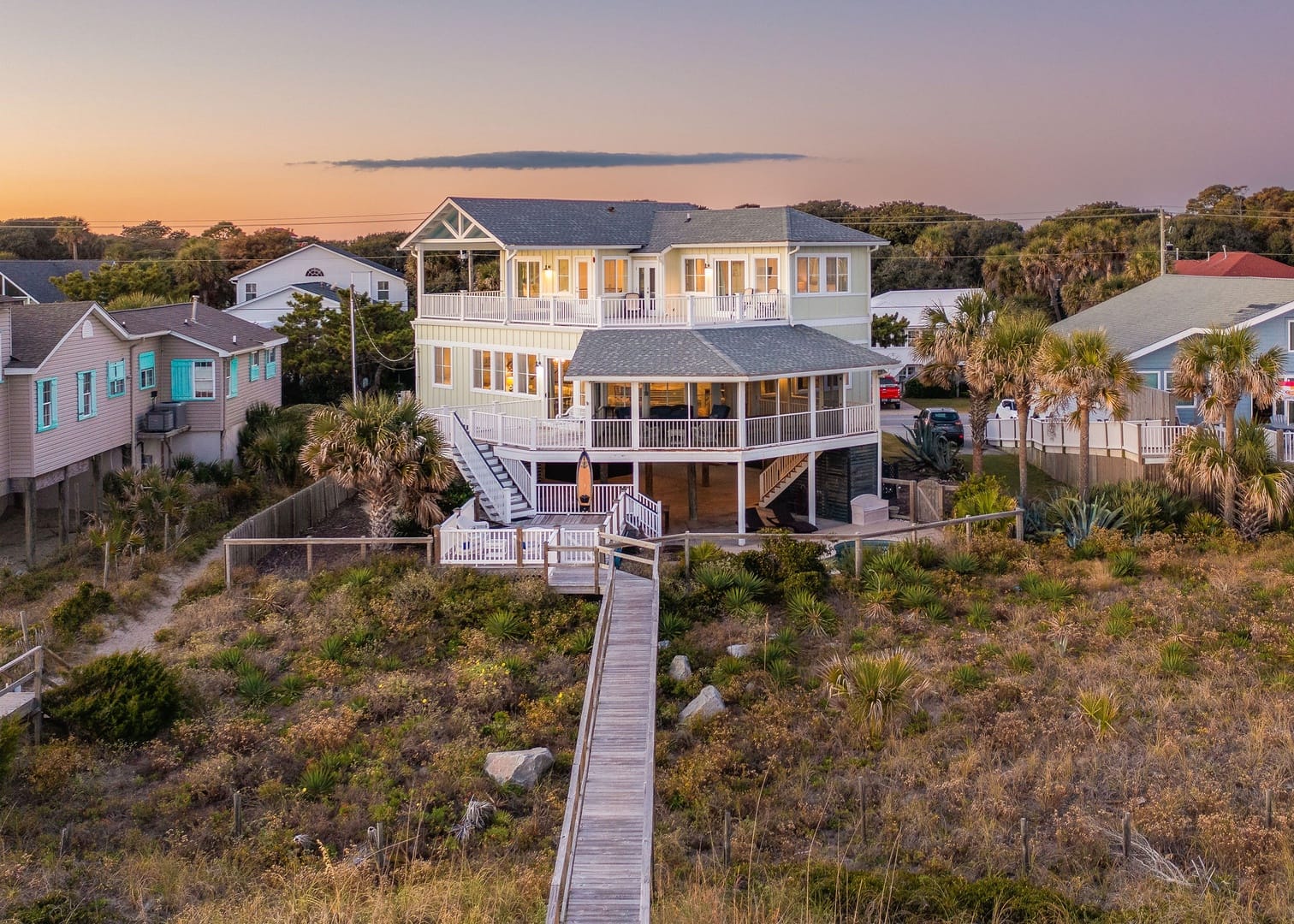 Exterior of home with boardwalk and grass surrounding the beach access
