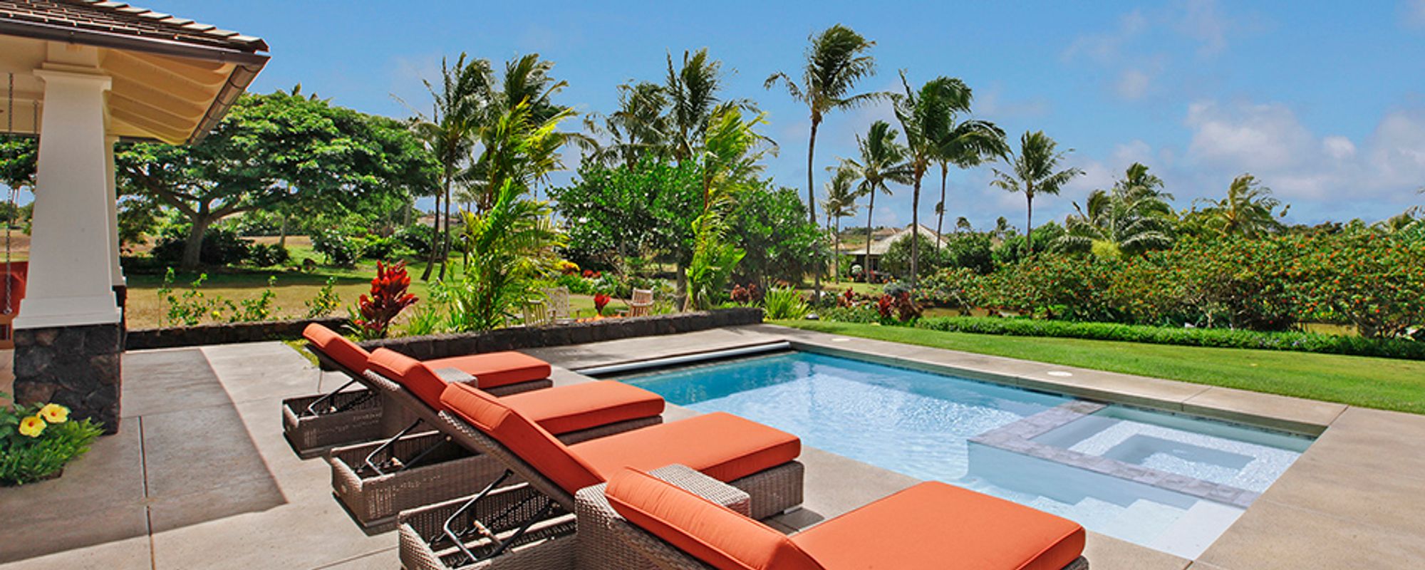 Lounge furniture by the pool at Kauai vacation rental home