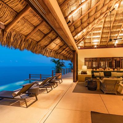 Indoor/outdoor living space with views of the private pool and the sea.