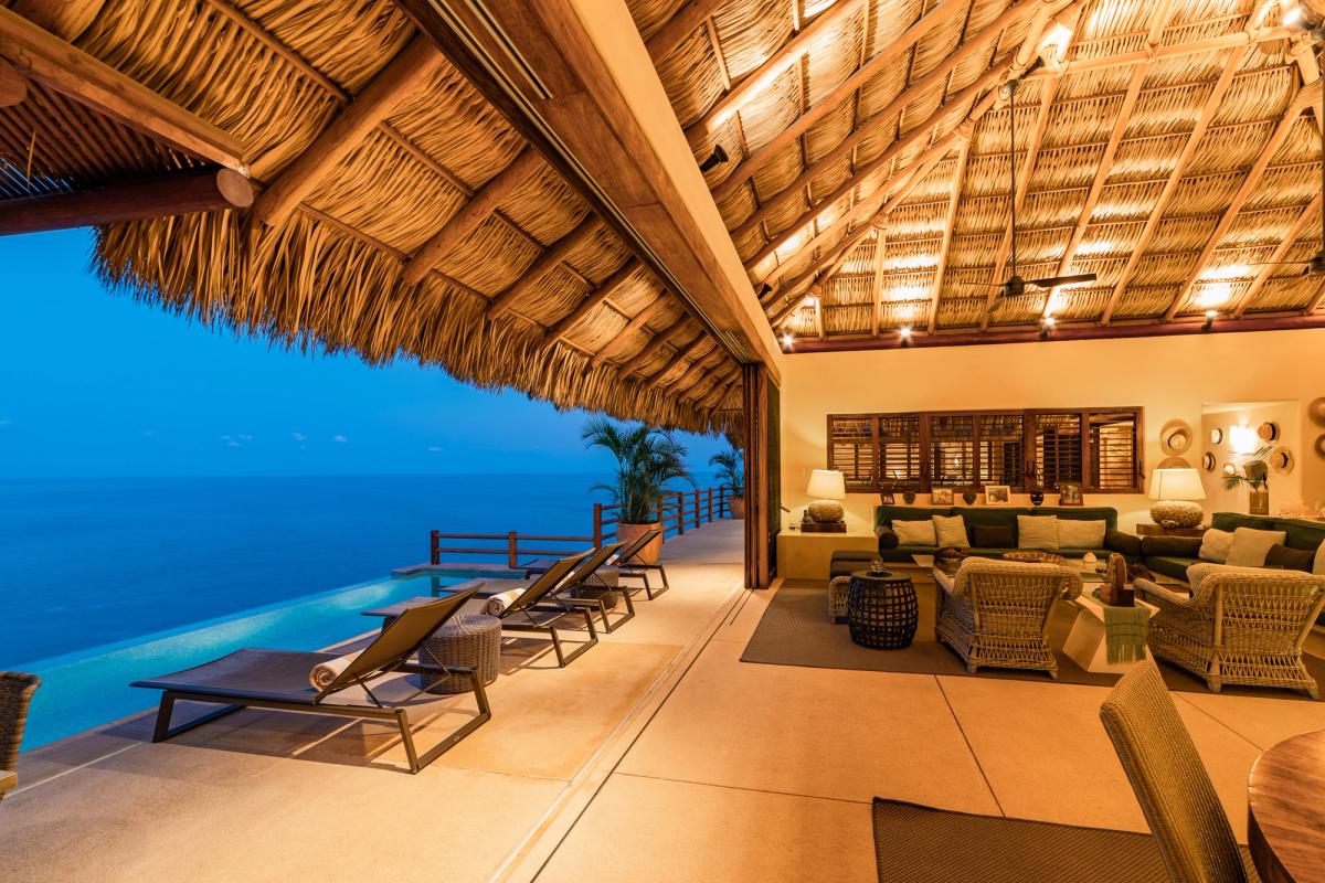 Indoor/outdoor living space with views of the private pool and the sea.