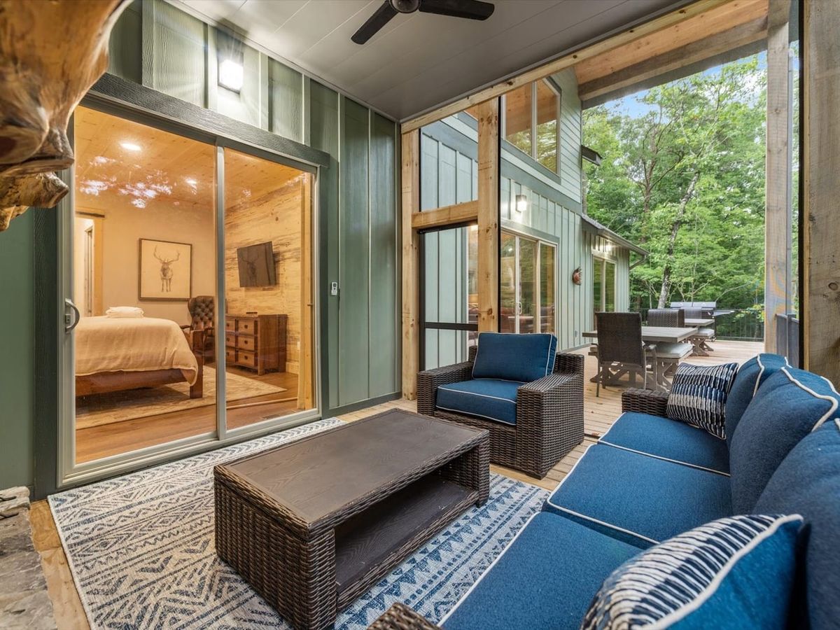 The covered outdoor patio at Creek Songs features cozy seating, forest views, and easy access to the main living space. It’s an ideal spot to relax, enjoy morning coffee, or unwind after a day exploring Blue Ridge.