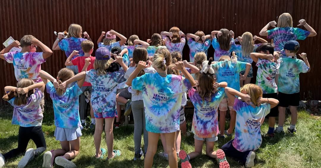 A group of children proudly show off their tie-dye shirts during the annual Snowshoe Shuffle event. Their playful poses and bright colors reflect a fun, family-friendly community gathering.