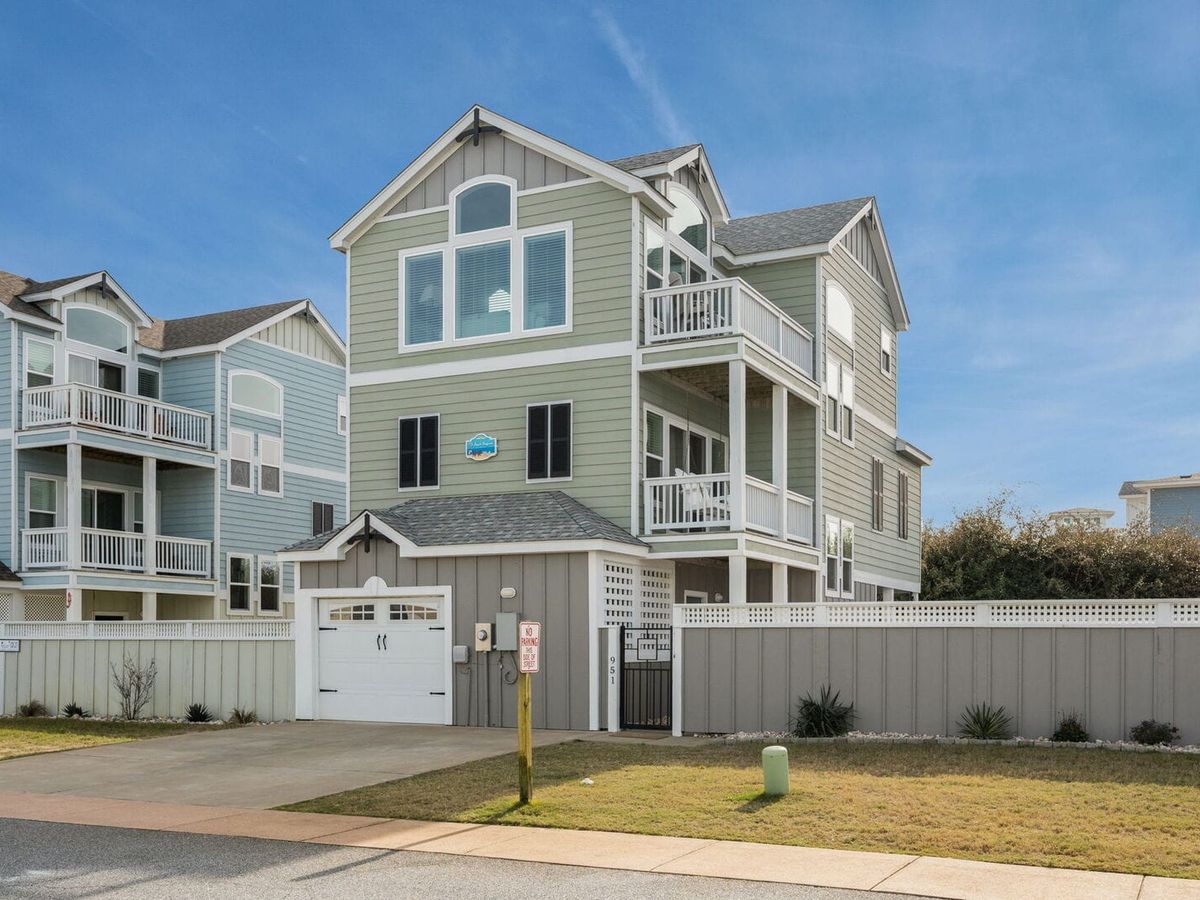 Located in the Outer Banks, this pet-friendly home has a private pool, hot tub, and fenced backyard. A game room with a wet bar and foosball table adds extra fun for family stays.