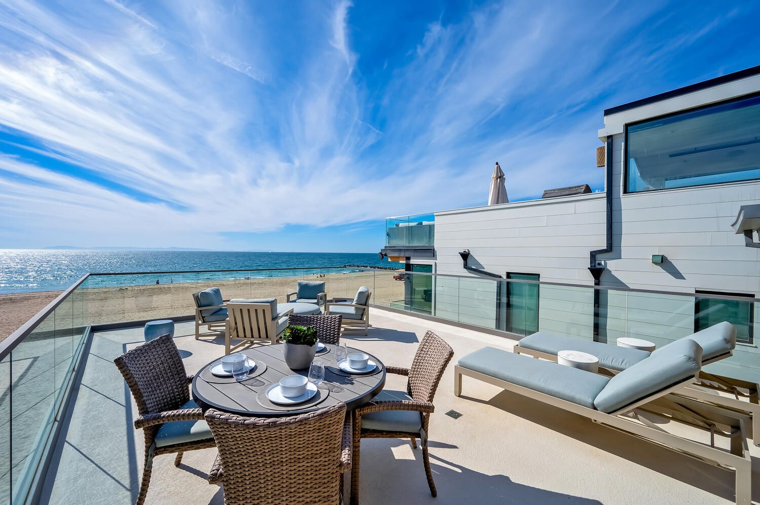 Rooftop patio with dining table and lounge chairs overlooking newport beach ca