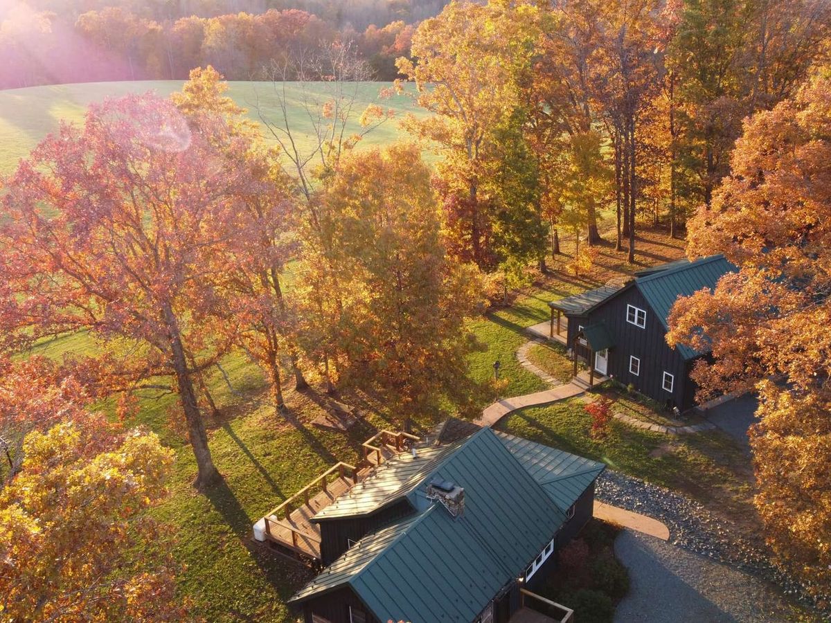 Golden sunlight pours over Rockfish Ranch, surrounded by rolling hills and autumn trees in full color. This peaceful retreat captures the magic of fall in Virginia, perfect for family gatherings and cozy evenings by the fire.